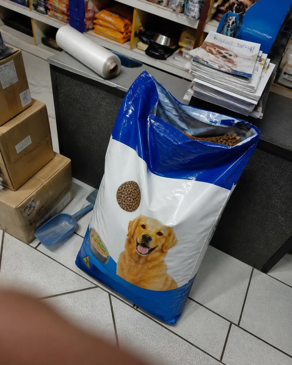 Foto do saco de ração jogado no canto do pet shop bagunçado